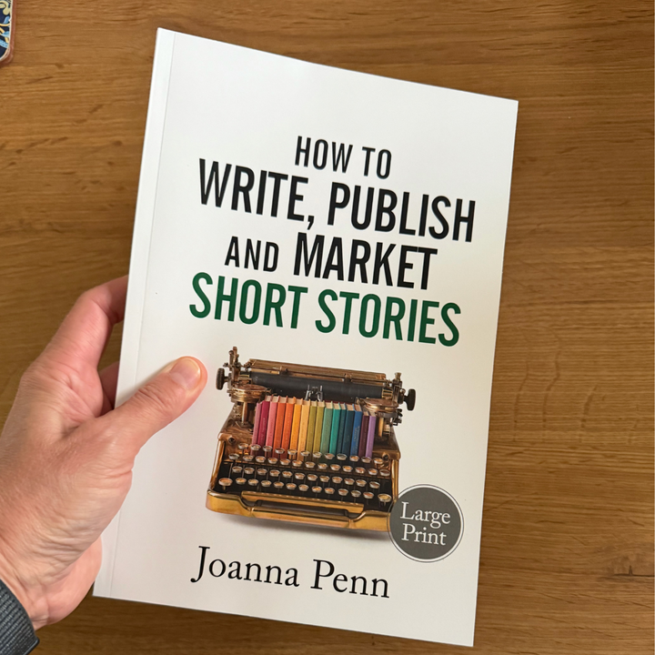 Hand holding the How to Write, Publish, and Market Short Stories Large Print edition by Joanna Penn